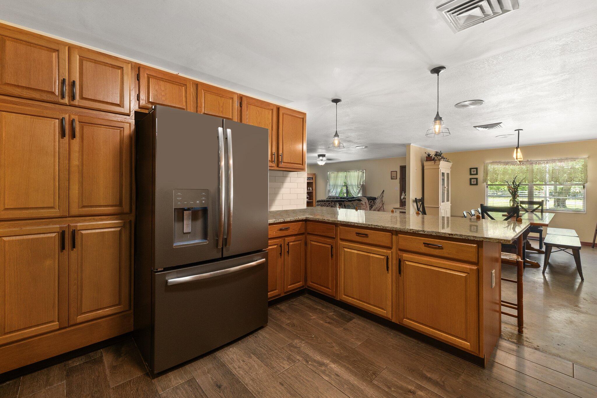 340 North Ffa Road Fort Pierce, FL 34945 - Photo 17 of 72 a kitchen with granite countertop stainless steel appliances a refrigerator a sink and cabinets