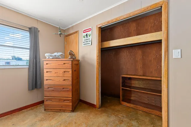 a bedroom with a bed a mirror on dresser and a window