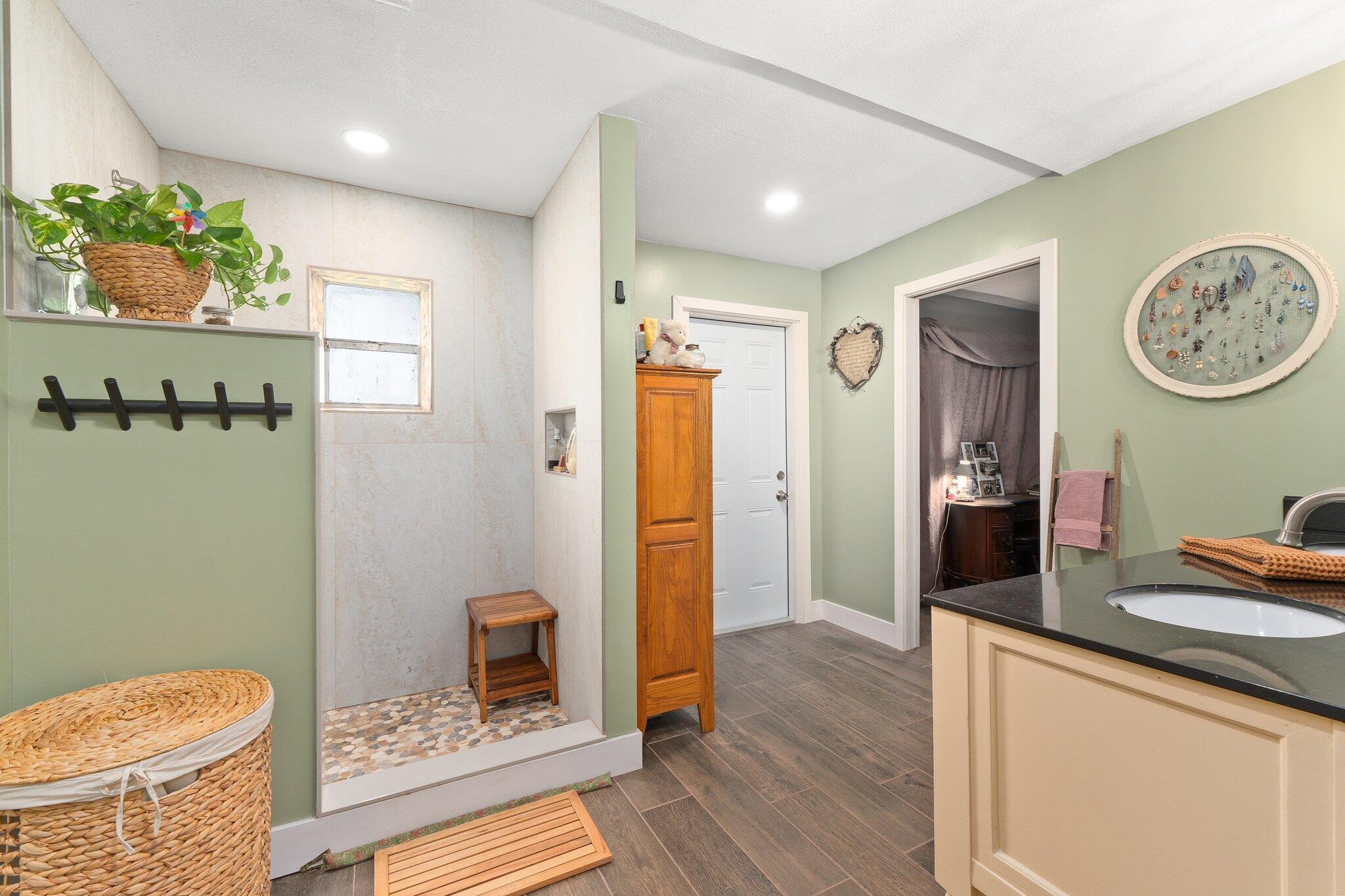 340 North Ffa Road Fort Pierce, FL 34945 - Photo 38 of 72 a spacious bathroom with a granite countertop sink a toilet a mirror and shower