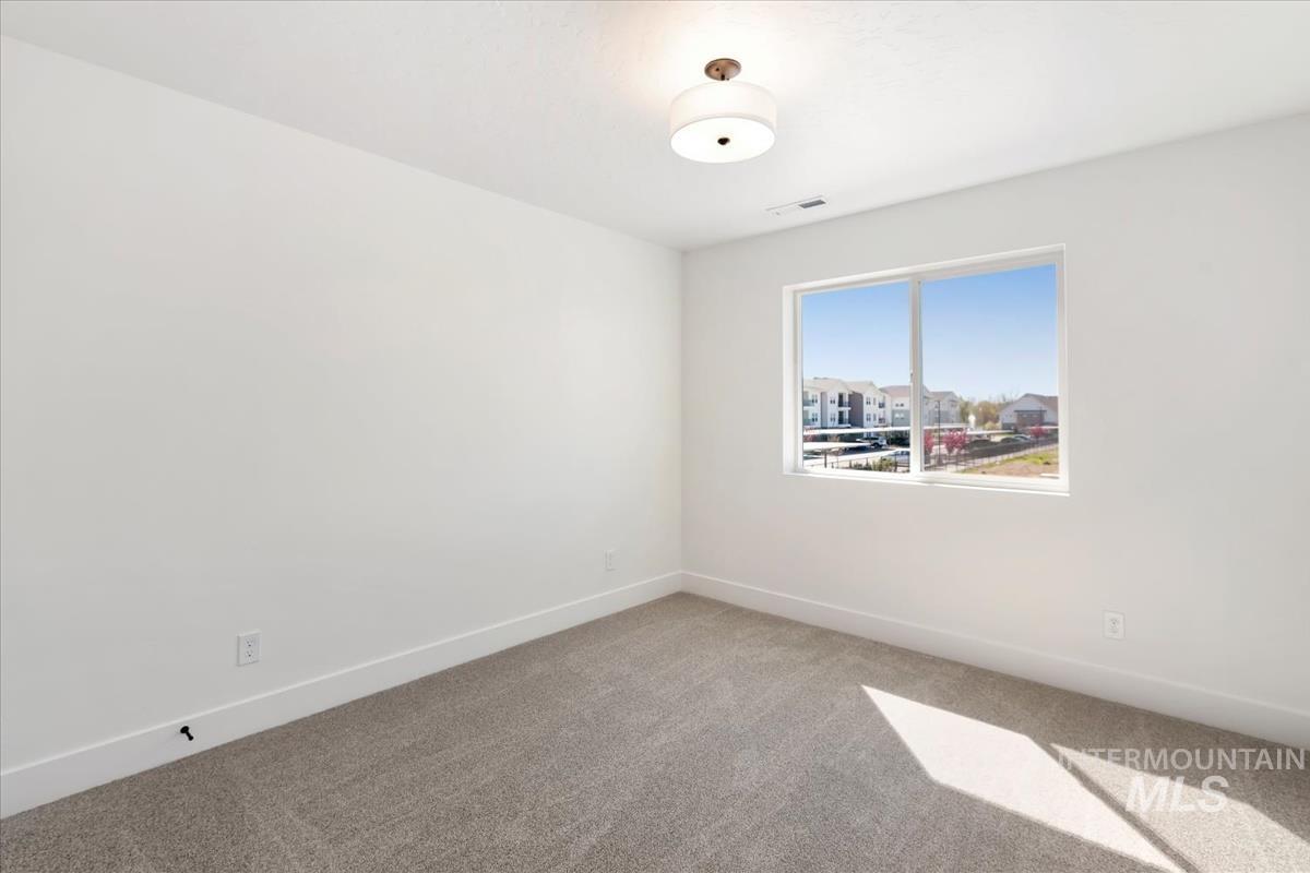 768 South Calhoun Lane Star, ID 83669 - Photo 28 of 36 Bright room featuring a large window, neutral carpeting, and a flush-mount ceiling light