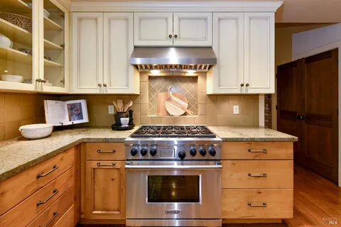 a view of kitchen with stainless steel appliances wooden floor
