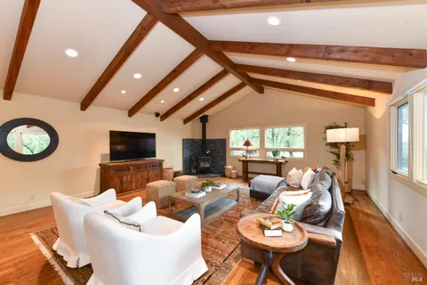 a living room with fireplace furniture and a large window
