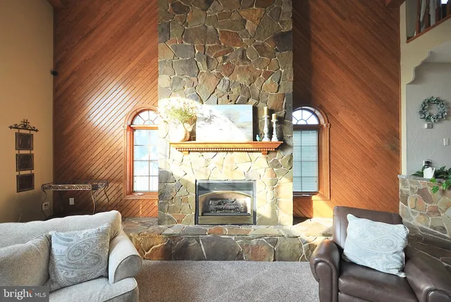 a living room with furniture fireplace and a large window