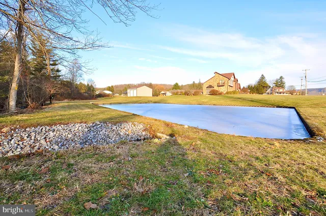 a backyard of a house with lots of green space and fountain
