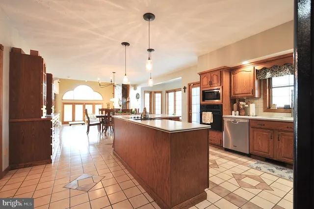 a large kitchen with granite countertop a large island in the center