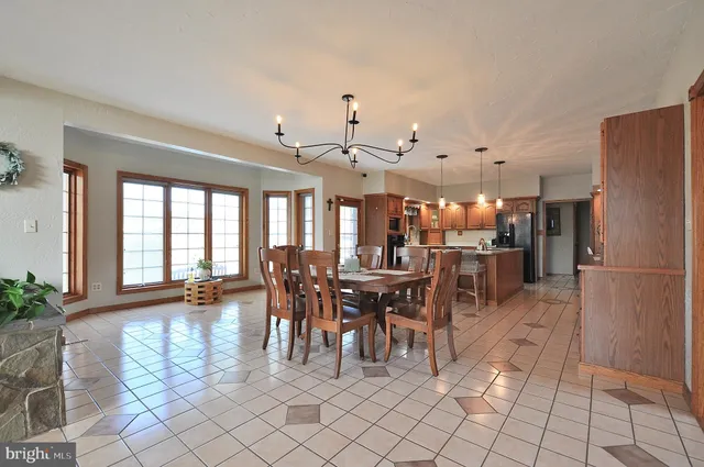 a living room with furniture a fireplace and a chandelier