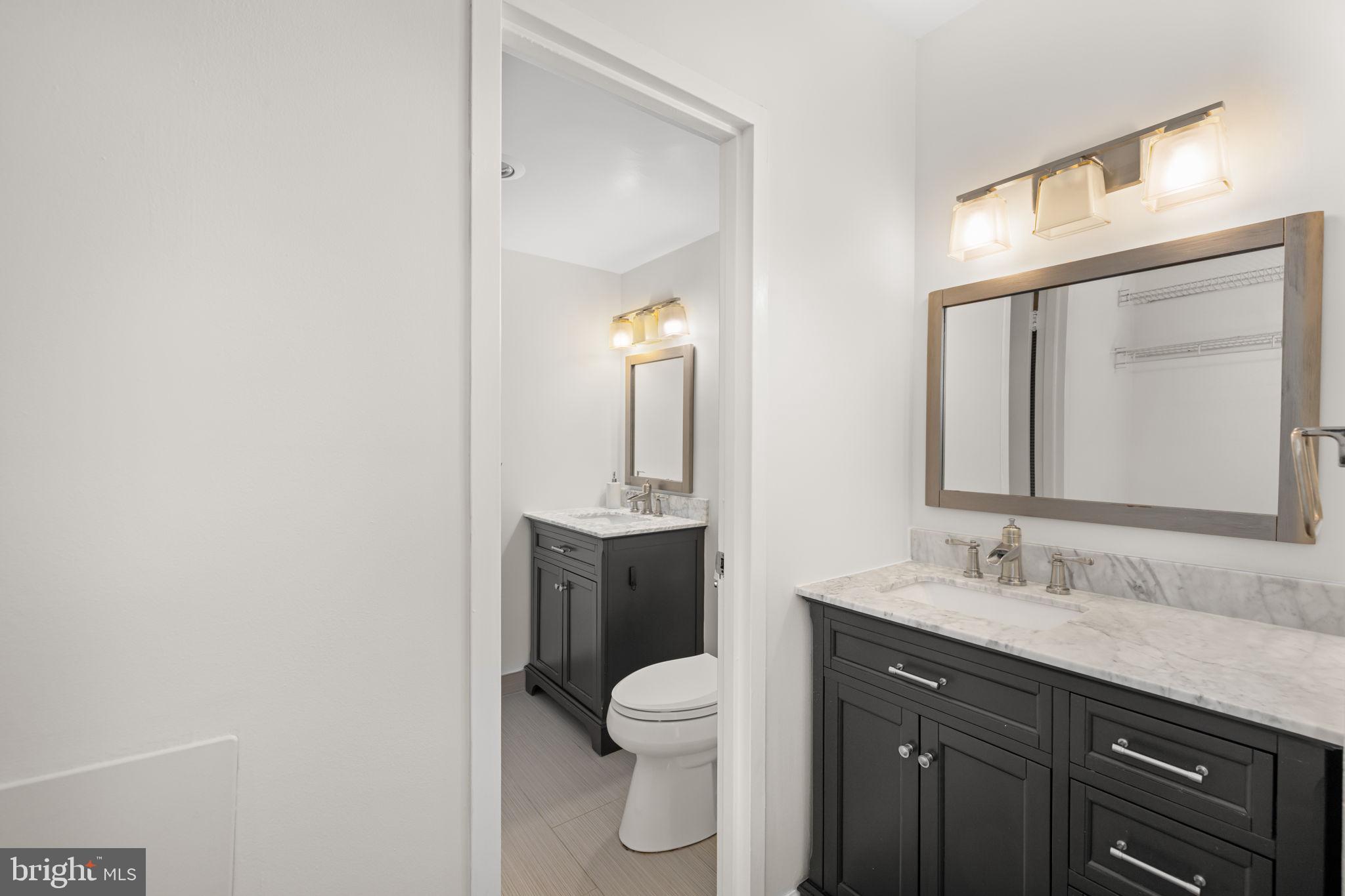 4100 Cathedral Avenue Northwest, Unit 712 Washington, DC 20016 - Photo 11 of 24 a bathroom with a toilet a sink a vanity and mirror