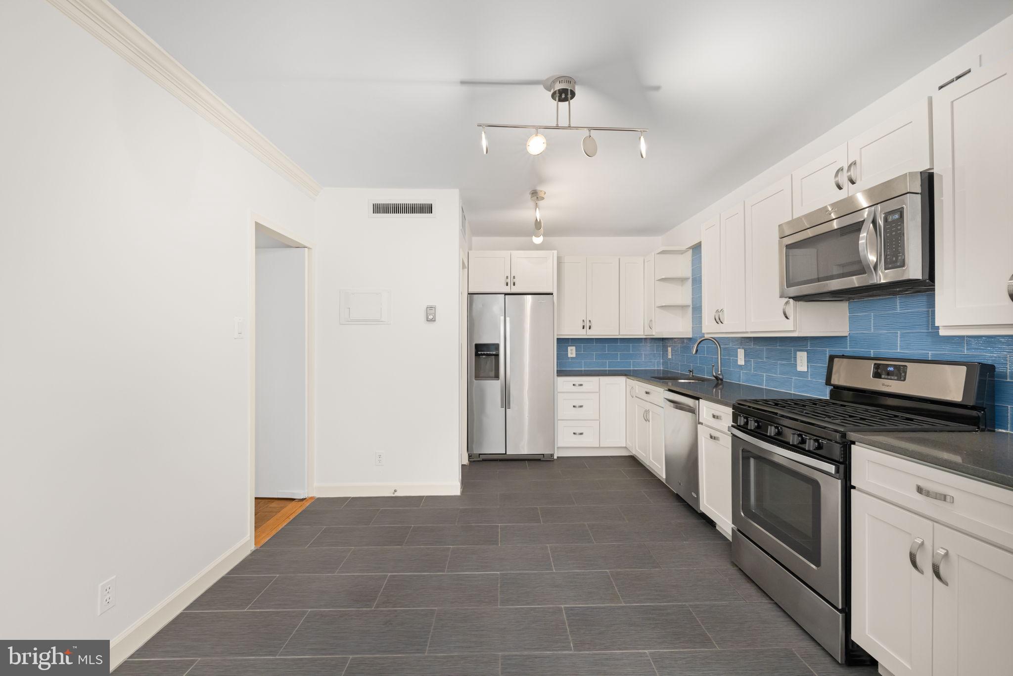 4100 Cathedral Avenue Northwest, Unit 712 Washington, DC 20016 - Photo 7 of 24 a large kitchen with cabinets stainless steel appliances and a counter space