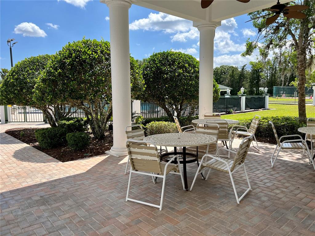 11273 Southwest 136th Place Dunnellon, FL 34432 - Photo 65 of 78 a view of a patio with table and chairs potted plants with wooden floor and fence