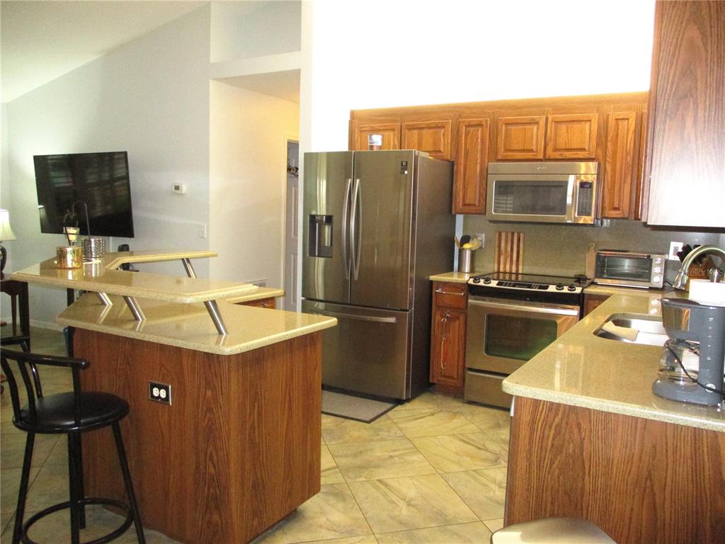 11273 Southwest 136th Place Dunnellon, FL 34432 - Photo 7 of 78 a kitchen with a sink refrigerator and microwave