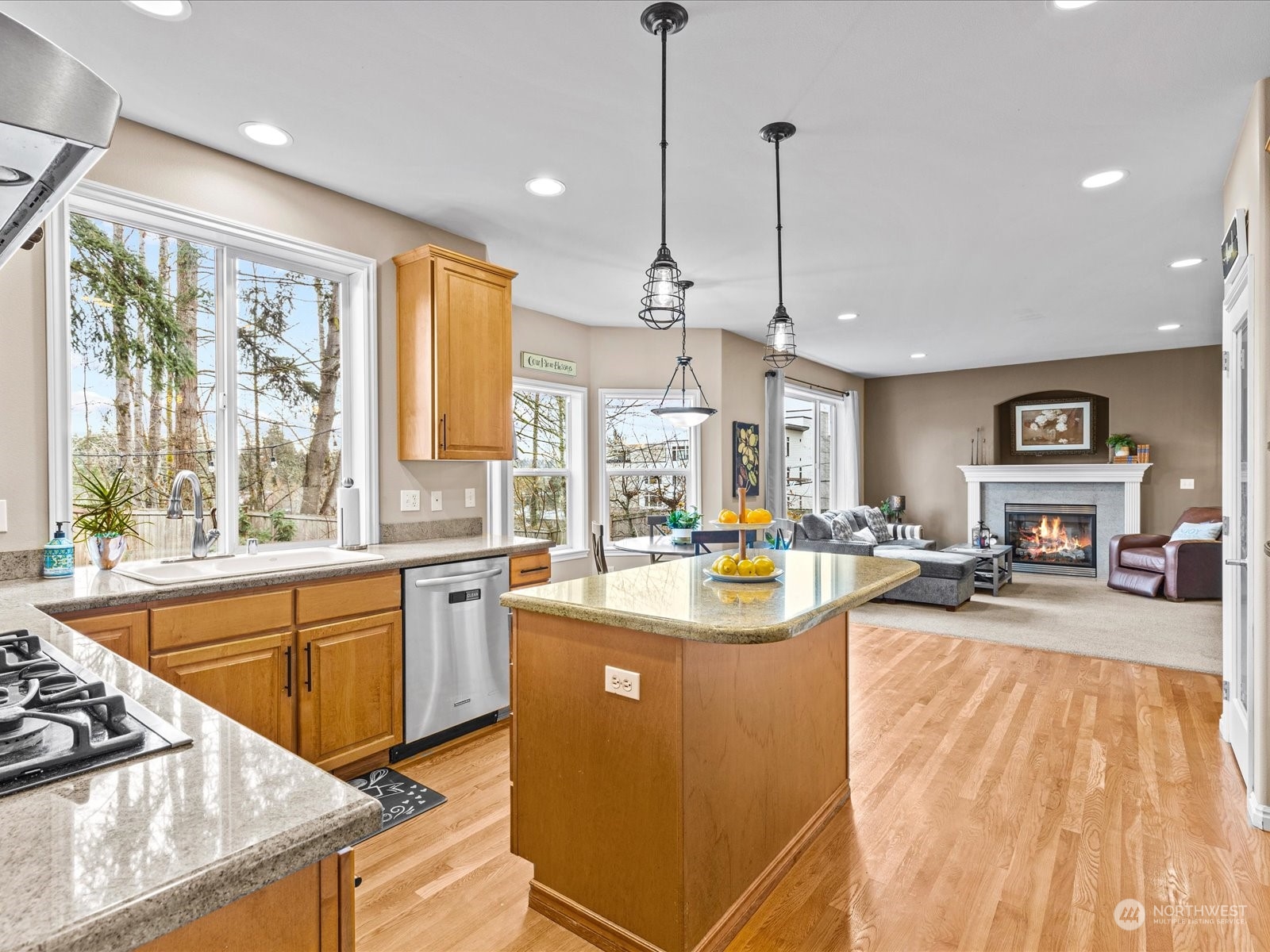 9506 Northeast 191st Street Bothell, WA 98011 - Photo 16 of 40 a view of a kitchen with kitchen island a large window cabinets a sink and stainless steel appliances