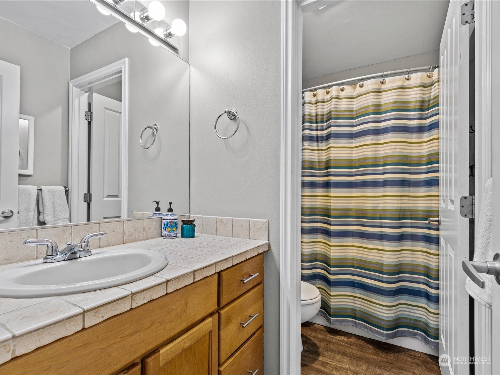 9506 Northeast 191st Street Bothell, WA 98011 - Photo 34 of 40 a bathroom with a sink a mirror and a shower