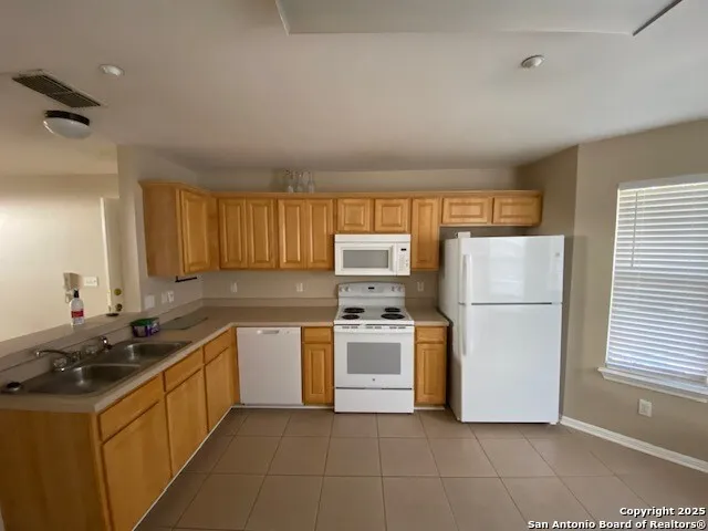 a kitchen with a sink a stove top oven and refrigerator