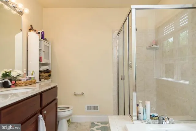 a bathroom with a sink vanity mirror and toilet
