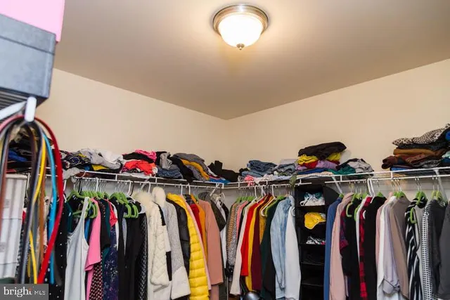a view of walk in closet with clothes