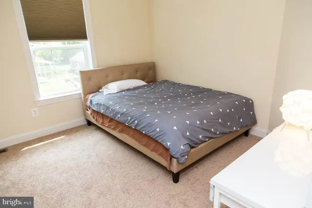 a bed sitting in a bedroom next to a window