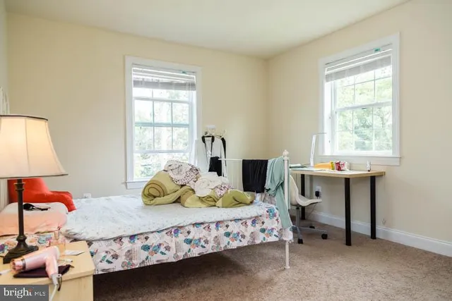 a bedroom with a bed chair and window