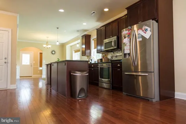 a kitchen with stainless steel appliances granite countertop a refrigerator and a stove top oven