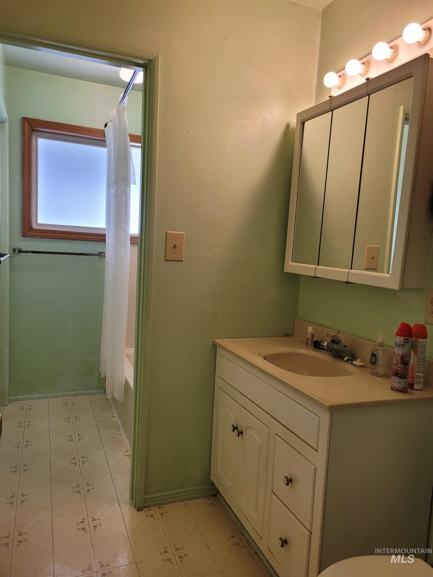 401 South 4th Street Rupert, ID 83350 - Photo 13 of 19 Full bath featuring vanity, shower / bathtub combination with curtain, and light flooring