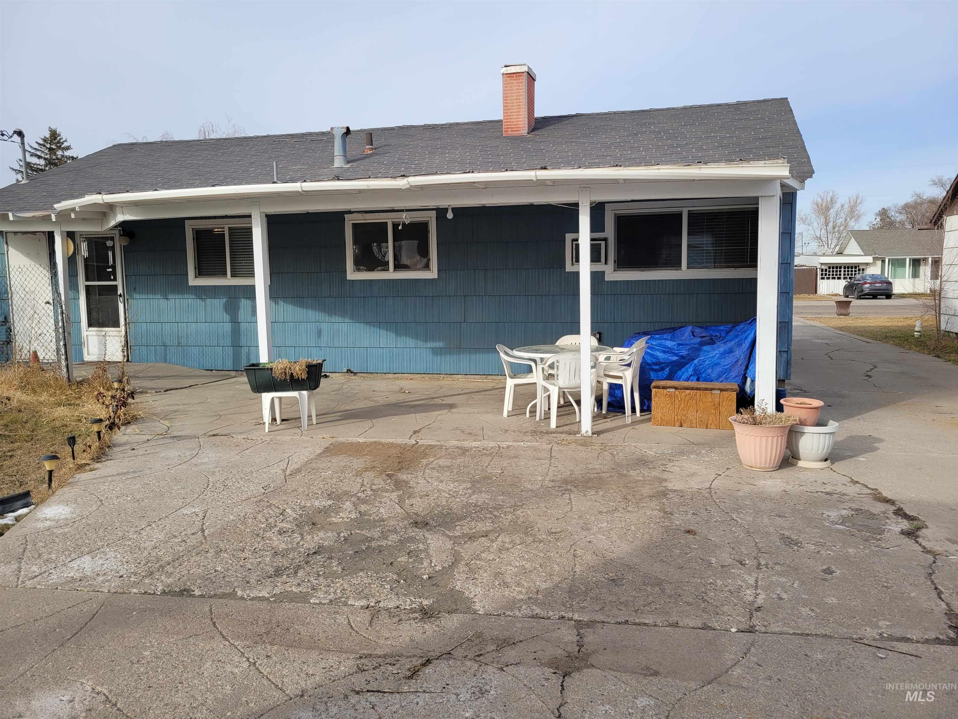 401 South 4th Street Rupert, ID 83350 - Photo 3 of 19 Back of property featuring outdoor dining space, roof with shingles, and a chimney