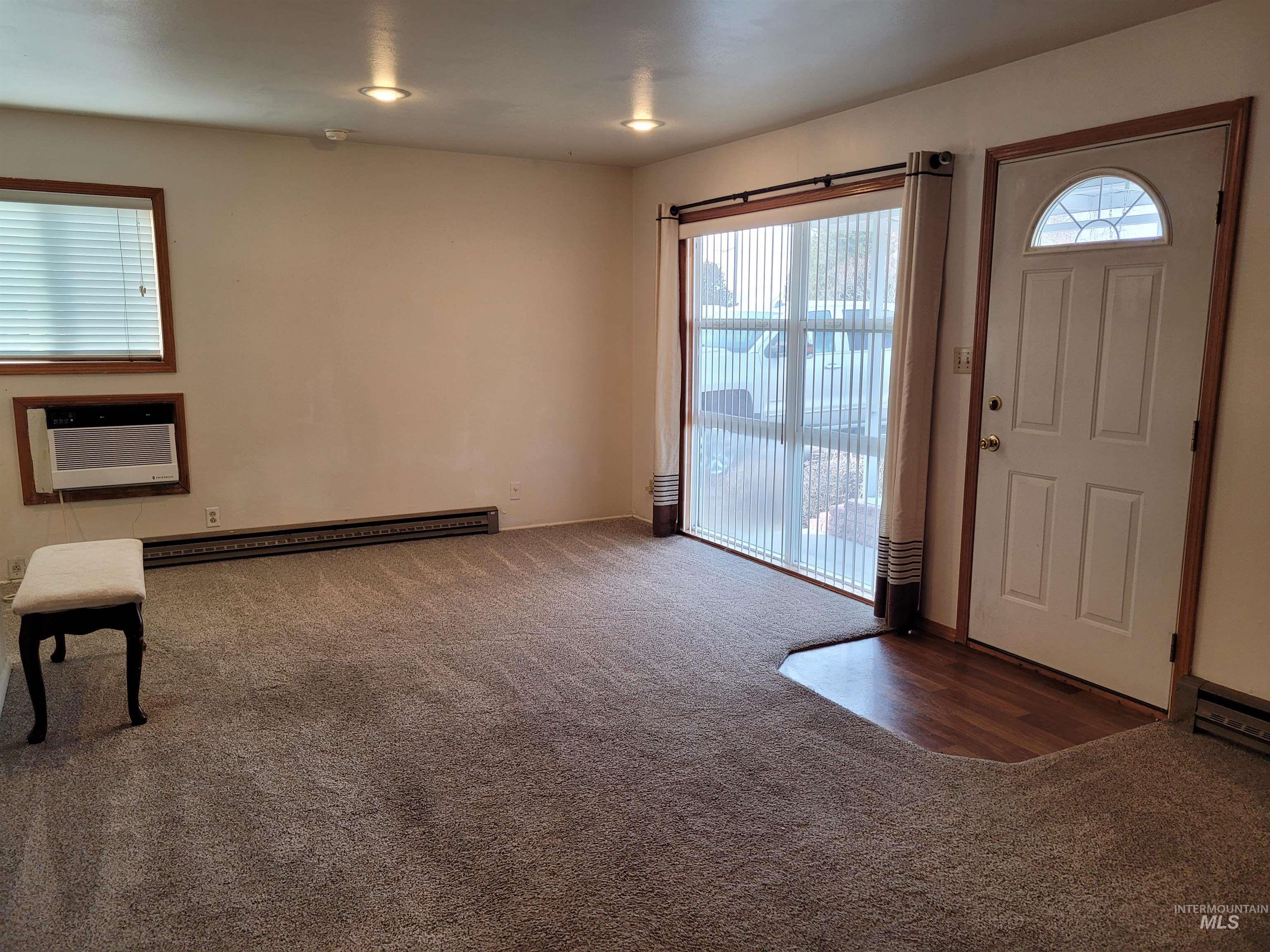 401 South 4th Street Rupert, ID 83350 - Photo 6 of 19 Entrance foyer featuring dark colored carpet and a wall mounted air conditioner