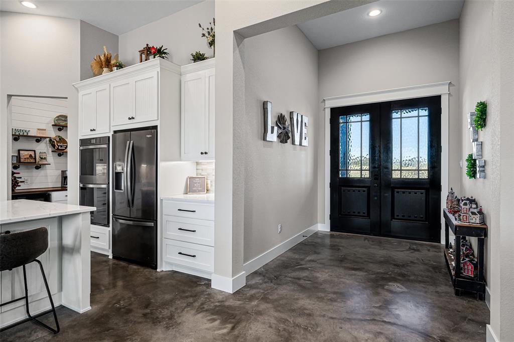 310 Runyan Rnch Road Tolar, TX 76476 - Photo 13 of 35 Kitchen featuring white cabinetry, finished concrete flooring, black fridge, recessed lighting, and double oven