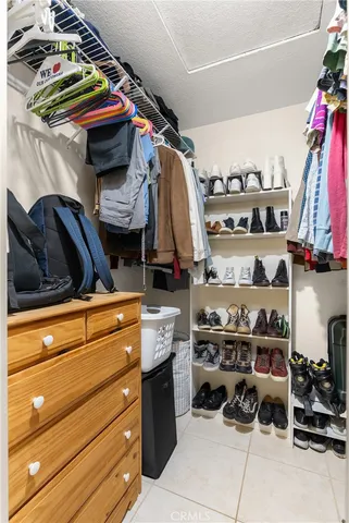a view of walk in closet with clothes and shoes