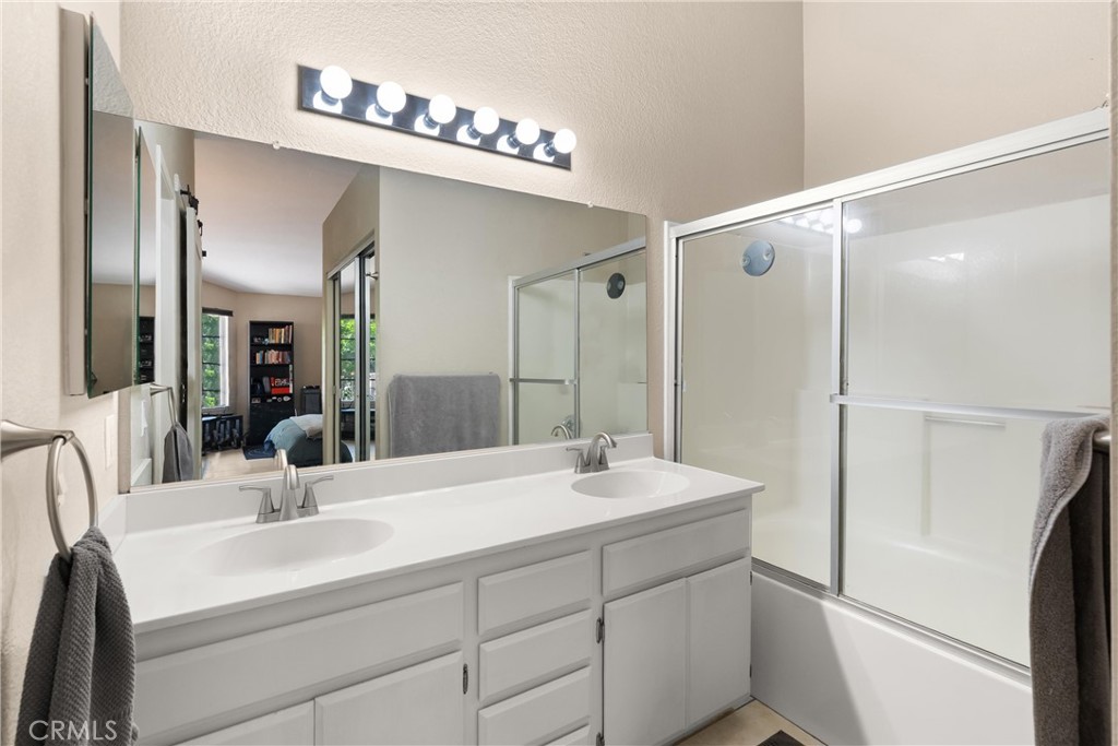 27 Castano Rancho Santa Margarita, CA 92688 - Photo 18 of 24 a bathroom with a double vanity sink a mirror and shower
