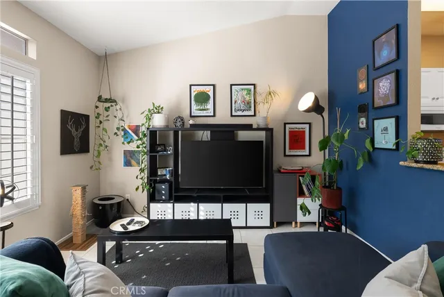 a living room with furniture a flat screen tv and a window