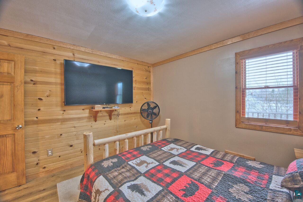 802 3rd Street Northwest Chisholm, MN 55719 - Photo 16 of 51 Bedroom with wooden walls and wood finished floors