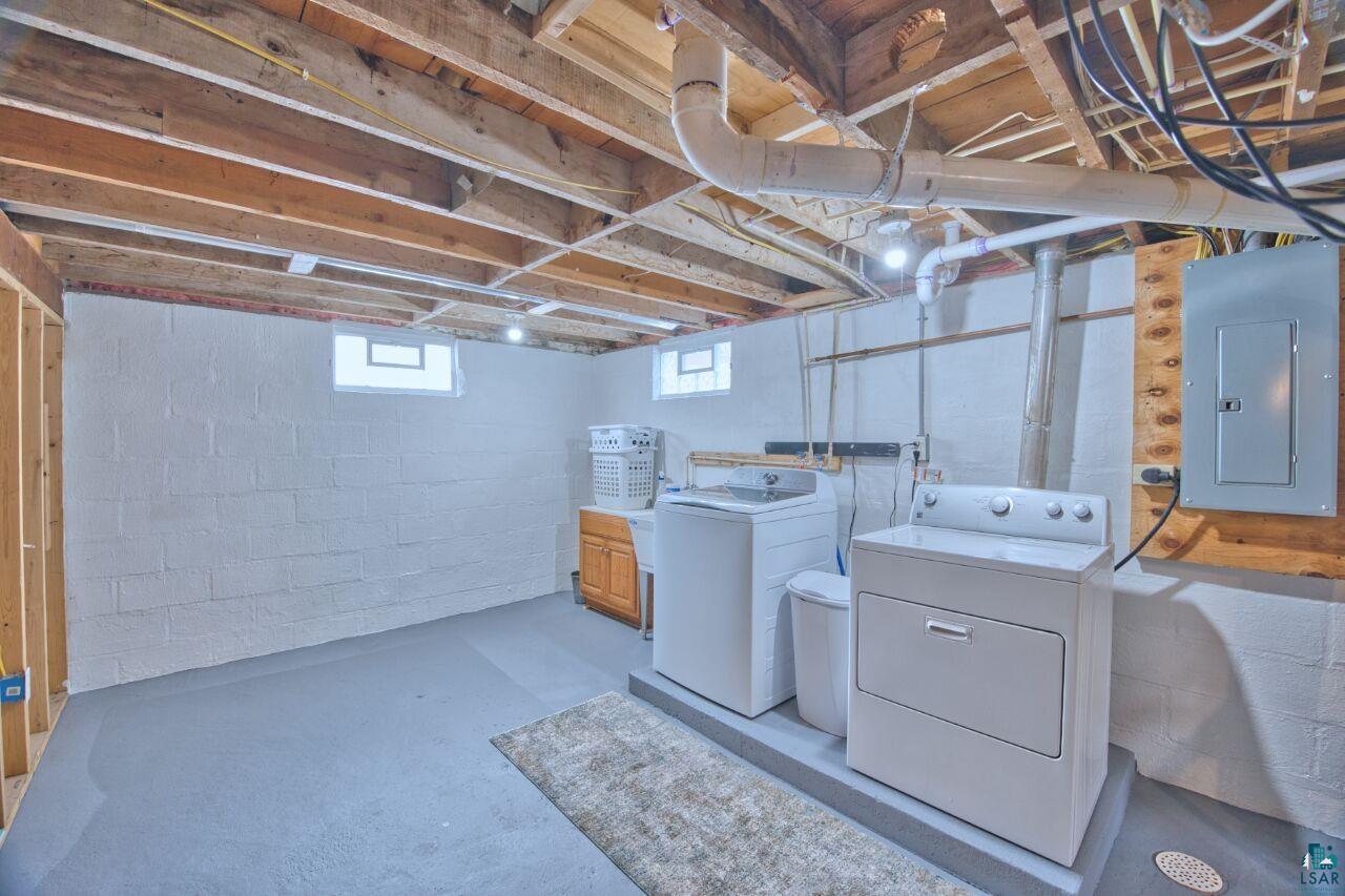 802 3rd Street Northwest Chisholm, MN 55719 - Photo 24 of 51 Laundry area with concrete flooring, electric panel, and washing machine and clothes dryer