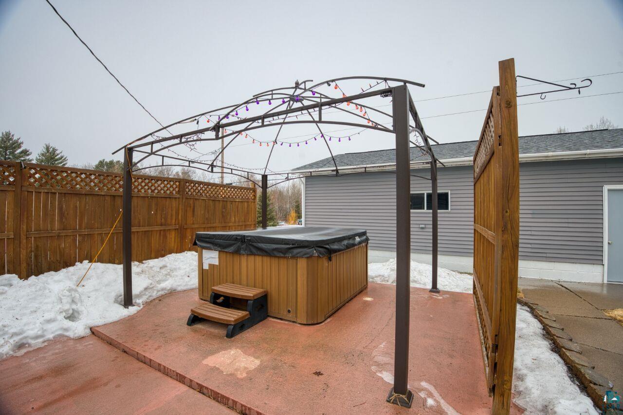802 3rd Street Northwest Chisholm, MN 55719 - Photo 31 of 51 Snow covered patio with a hot tub and a patio area
