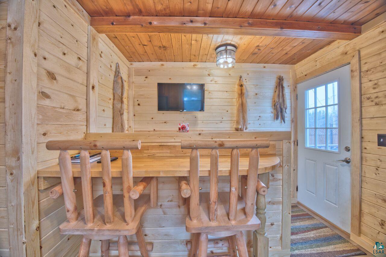 802 3rd Street Northwest Chisholm, MN 55719 - Photo 9 of 51 Unfurnished dining area featuring a relaxing sauna, wooden walls, and a wood ceiling with exposed beams