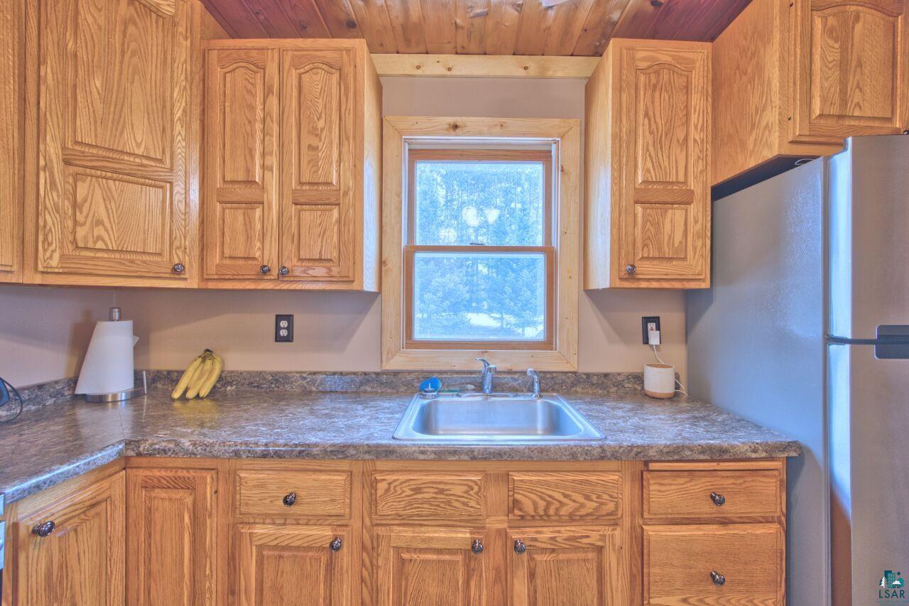 802 3rd Street Northwest Chisholm, MN 55719 - Photo 10 of 51 Kitchen featuring freestanding refrigerator, dark countertops, wood finish cabinets, and wood ceiling