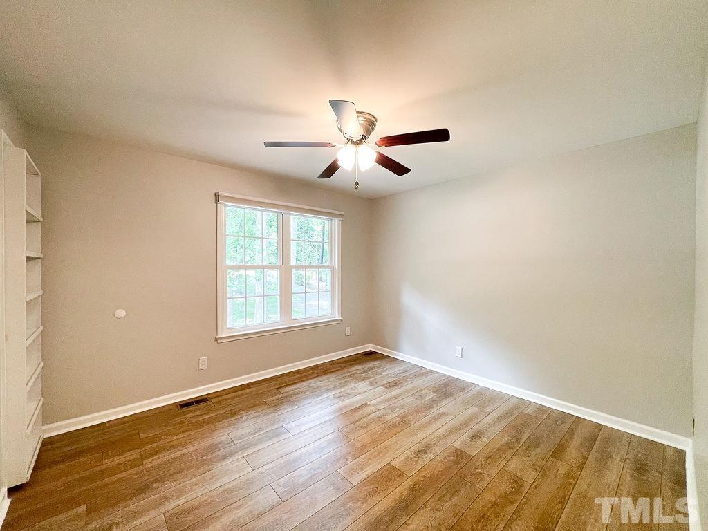 6700 Laurdane Road Raleigh, NC 27613 - Photo 12 of 25 a view of an empty room with window and wooden floor