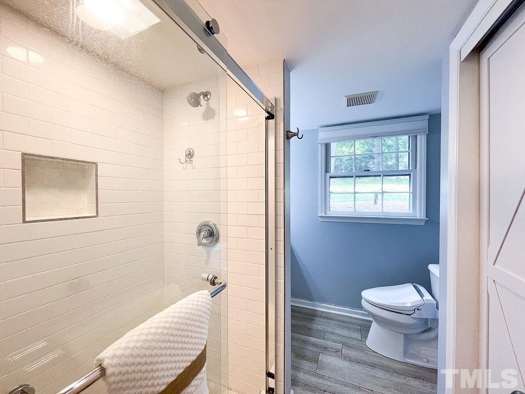 6700 Laurdane Road Raleigh, NC 27613 - Photo 17 of 25 a bathroom with a toilet a sink and a window
