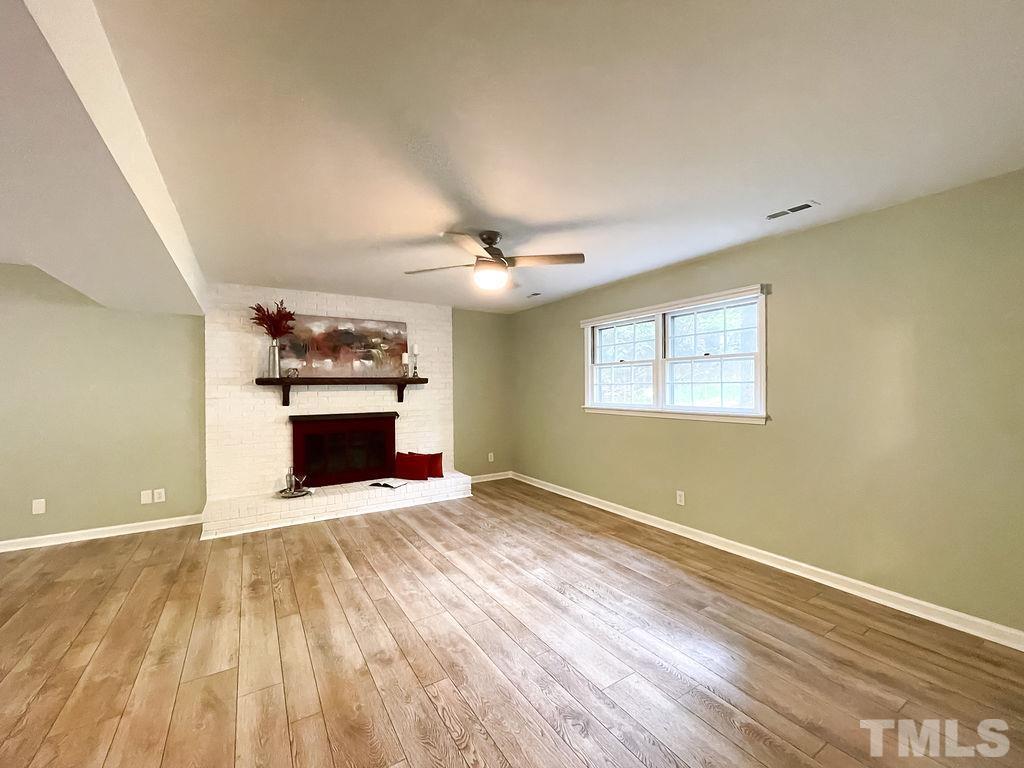 6700 Laurdane Road Raleigh, NC 27613 - Photo 18 of 25 a view of empty room with a fireplace and wooden floor