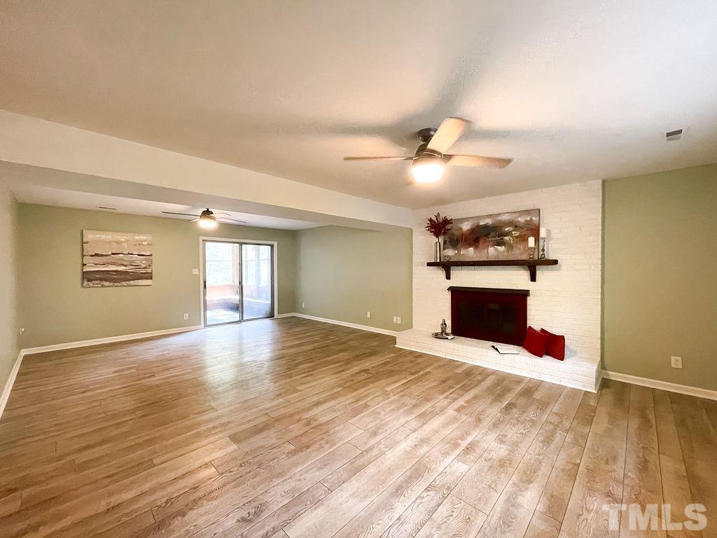 6700 Laurdane Road Raleigh, NC 27613 - Photo 19 of 25 a view of empty room with a fireplace and wooden floor