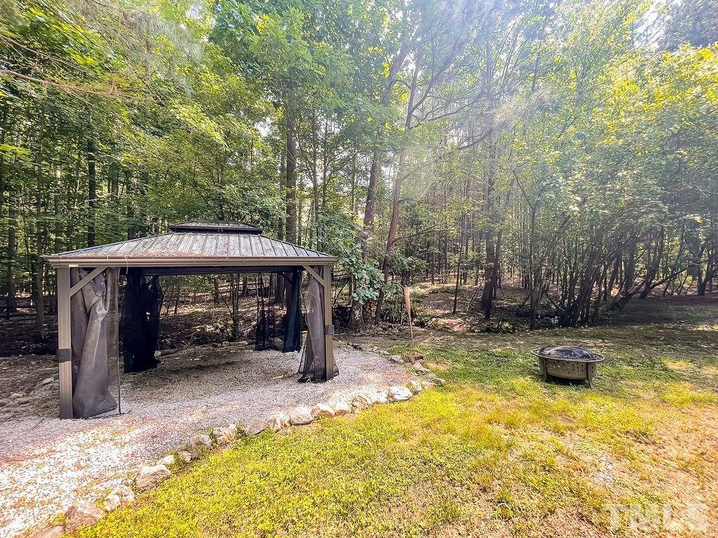 6700 Laurdane Road Raleigh, NC 27613 - Photo 25 of 25 a view of a patio with table and chairs under an umbrella