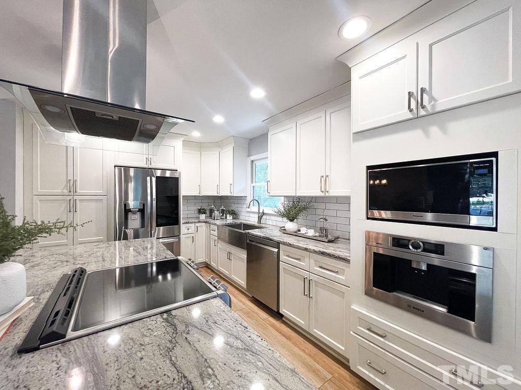 6700 Laurdane Road Raleigh, NC 27613 - Photo 5 of 25 a kitchen with stainless steel appliances granite countertop a stove a sink and a microwave
