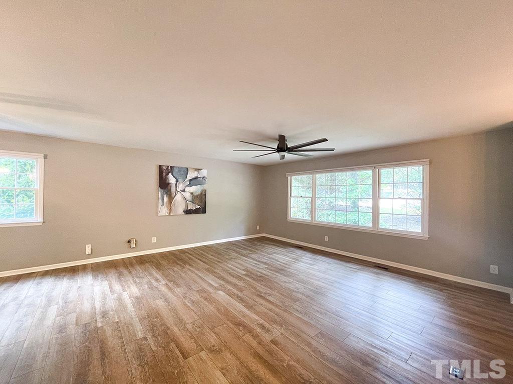 6700 Laurdane Road Raleigh, NC 27613 - Photo 7 of 25 an empty room with wooden floor and windows