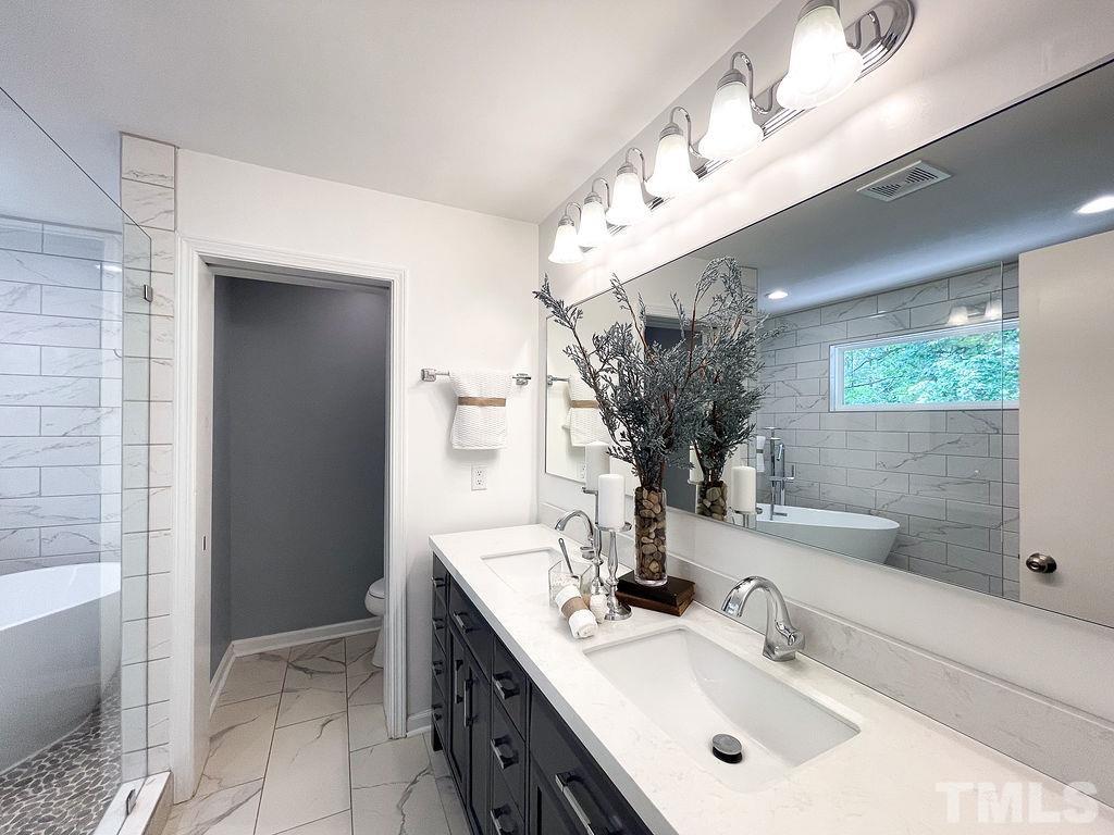 6700 Laurdane Road Raleigh, NC 27613 - Photo 9 of 25 a bathroom with a sink and a mirror