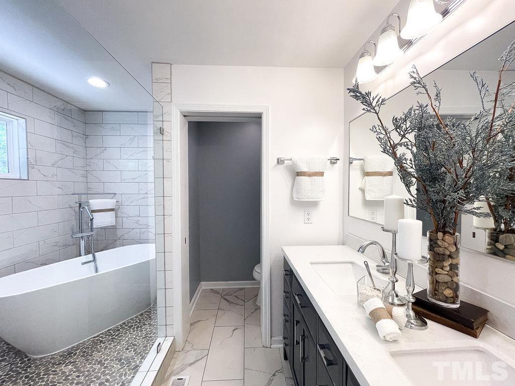 6700 Laurdane Road Raleigh, NC 27613 - Photo 10 of 25 a bathroom with a bathtub a sink and a shower