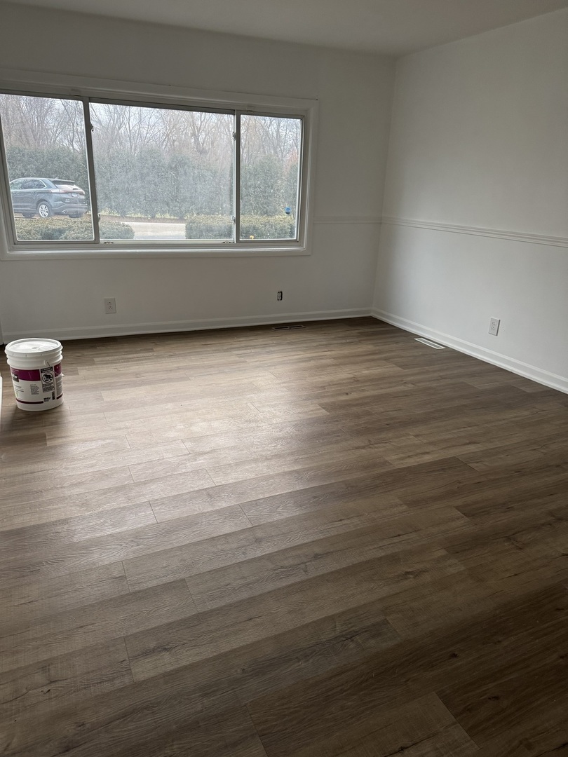 106 Valley View Drive, Unit 106 McHenry, IL 60050 - Photo 5 of 7 an empty room with wooden floor and windows