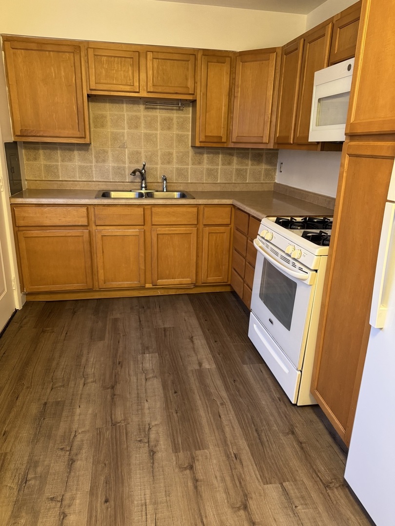 106 Valley View Drive, Unit 106 McHenry, IL 60050 - Photo 6 of 7 a kitchen with wooden floors and white appliances