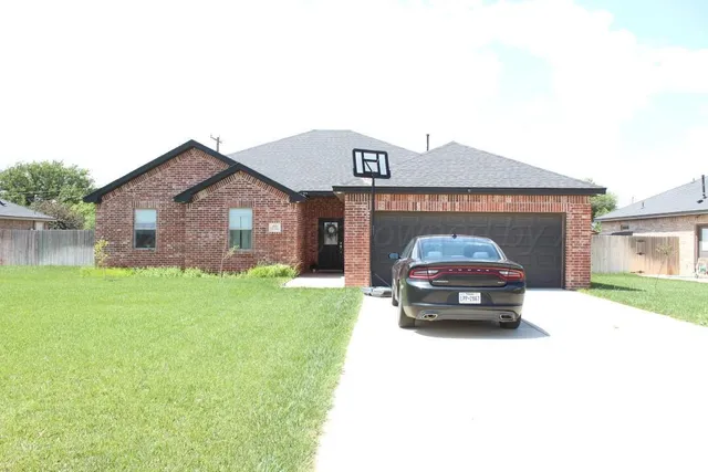 a car parked in front of a house and a yard