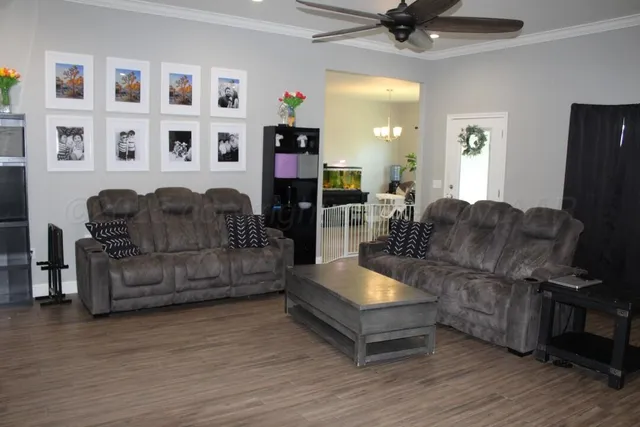 a living room with furniture and a wooden floor