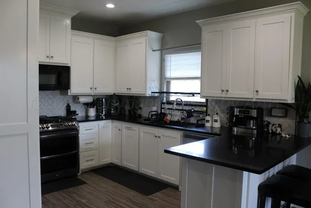 a kitchen with stainless steel appliances a sink a stove and cabinets