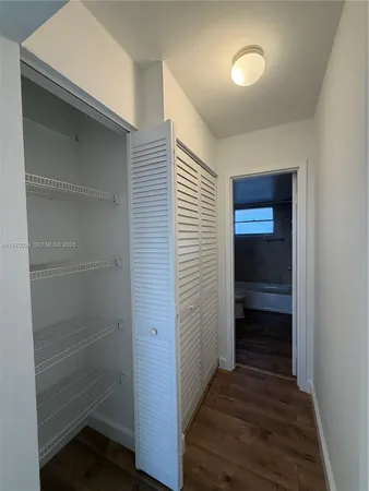 a view of a room with wooden floor and cabinets