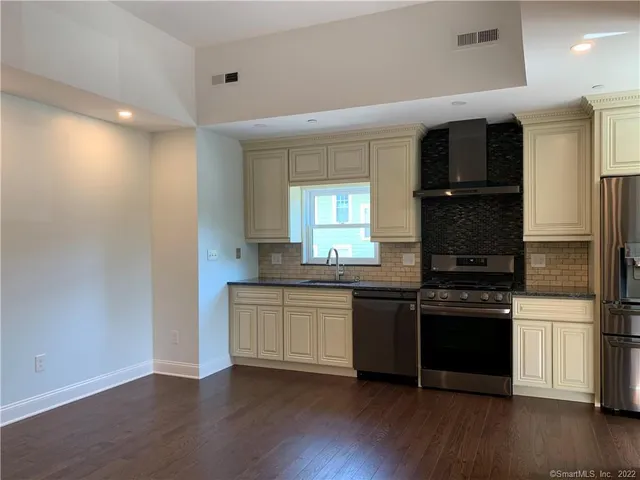 a kitchen with stainless steel appliances granite countertop a refrigerator and a stove top oven